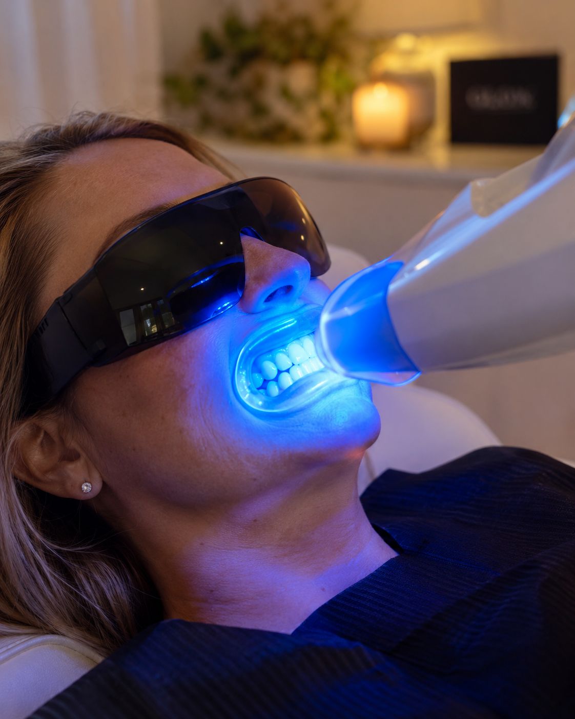 Guest wearing protective eyewear as the blue whitening light works during her 60-minute teeth whitening session at Bright Now in Prescott, AZ